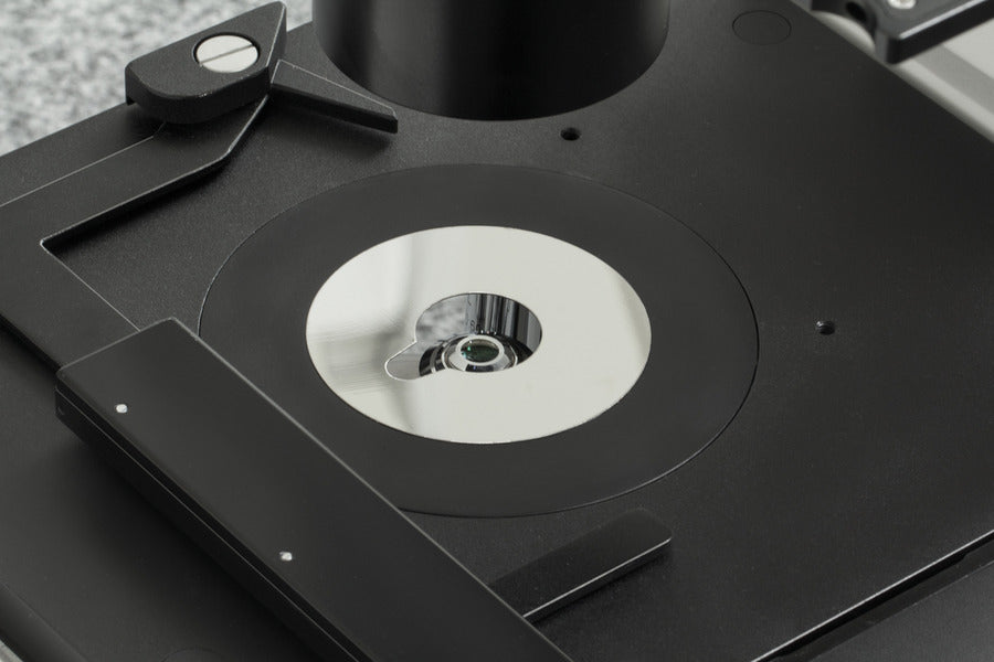 Close-up of microscope stage with condenser lens